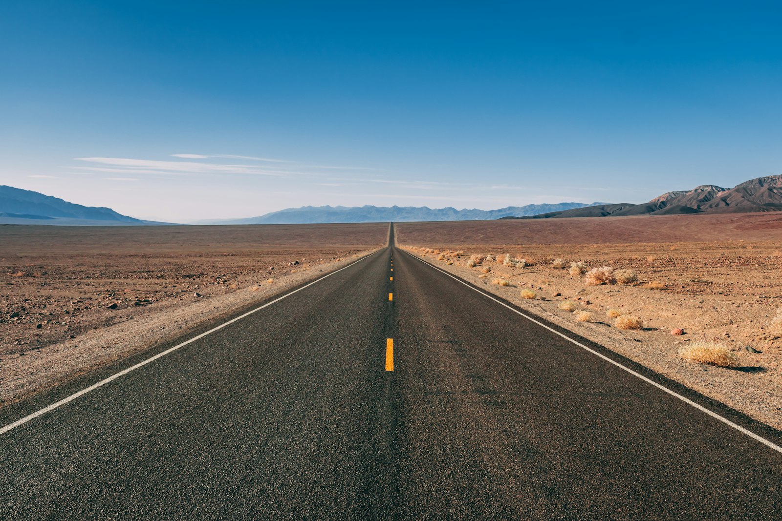 Long desert highway stretching toward the horizon, where drivers often receive out-of-state traffic tickets