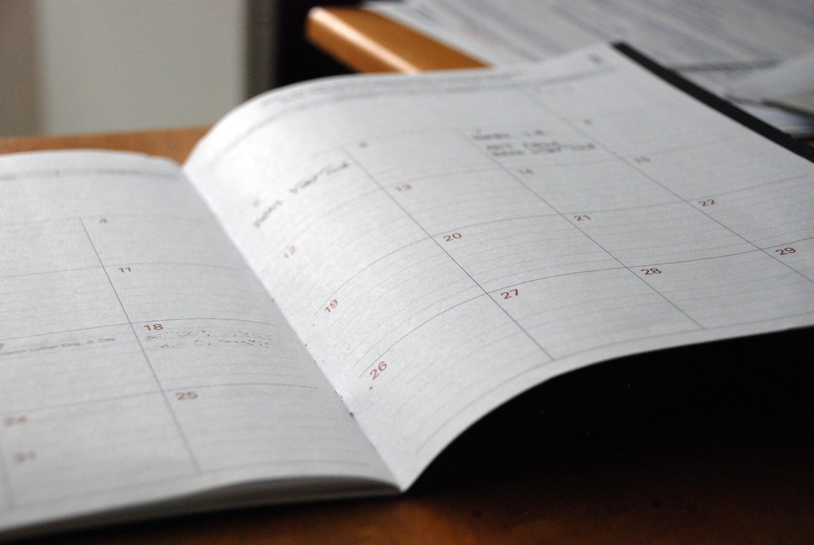 Open monthly planner on a desk representing appointment scheduling software for service businesses