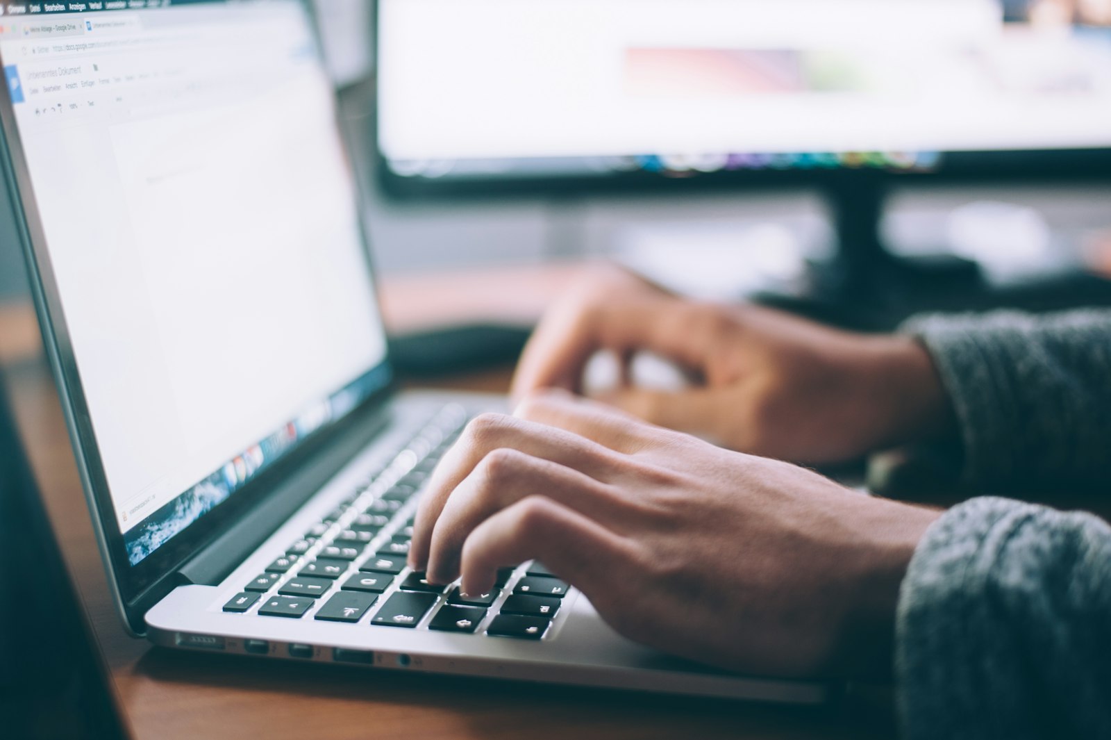 Person typing on a laptop to convert Cyrillic to Latin script online