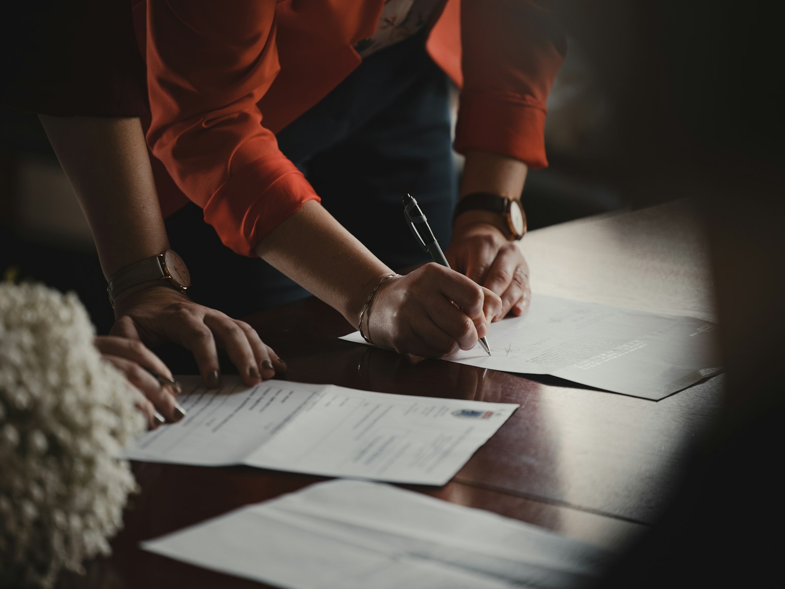 Person reviewing and signing a job offer document at a desk before negotiating