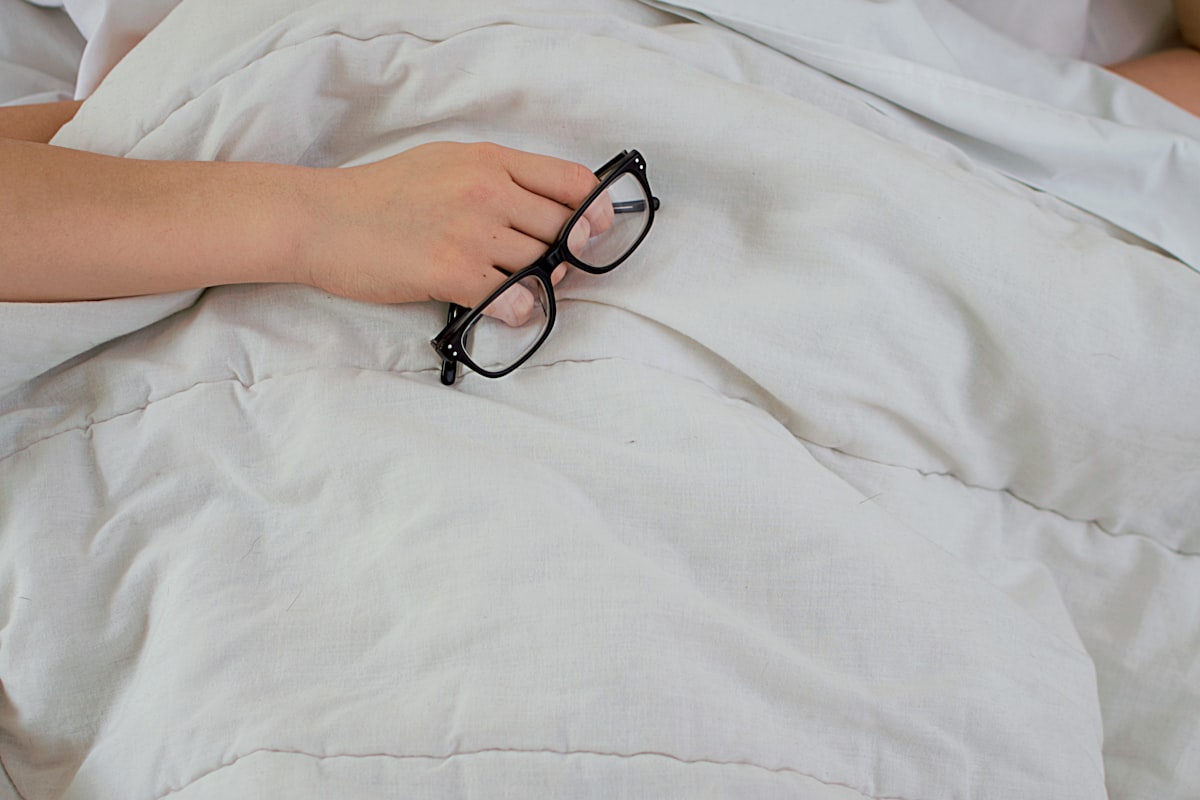 Person lying awake in bed at night struggling to fall asleep