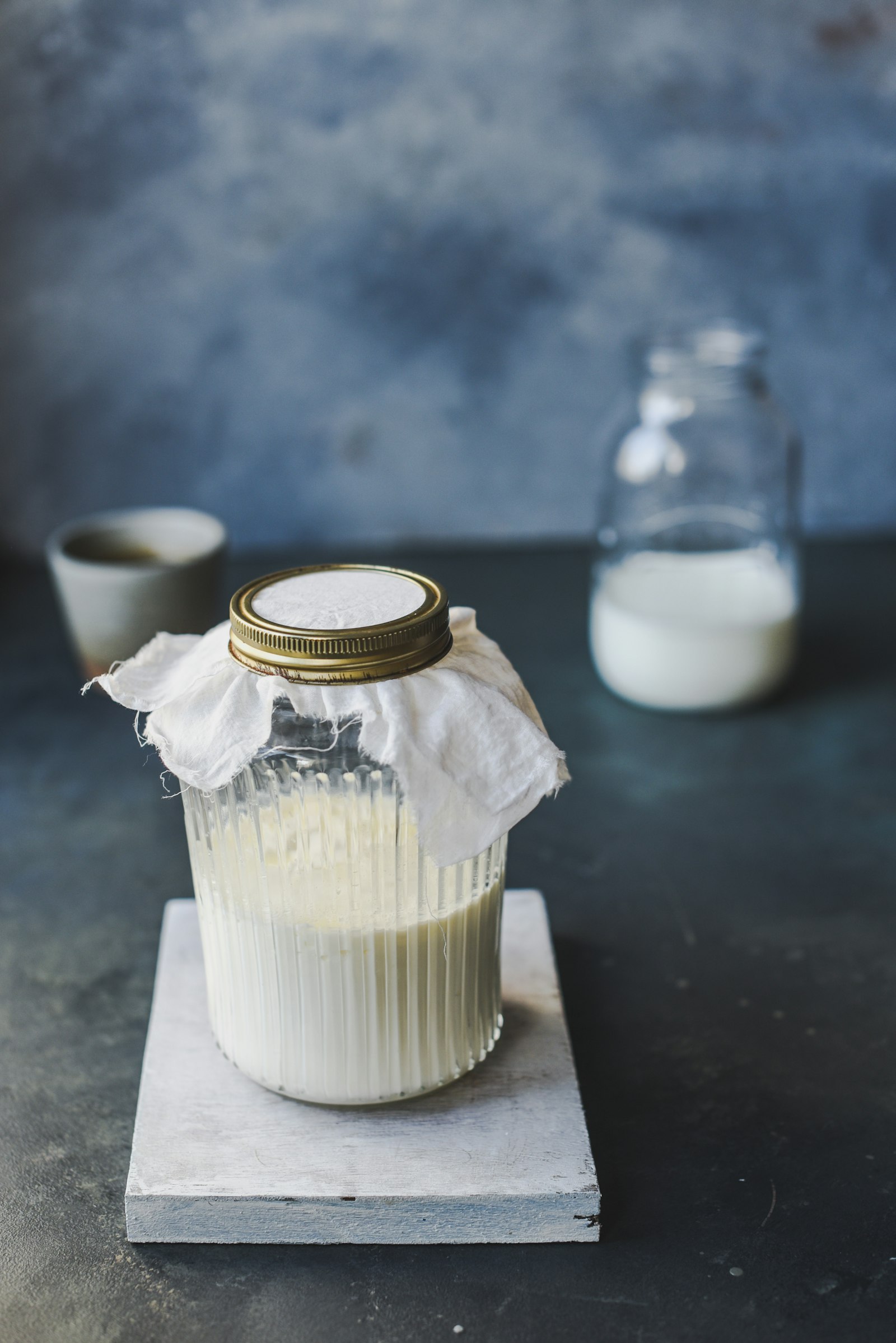 Glass jar of kefir, a probiotic fermented drink, on a wooden surface