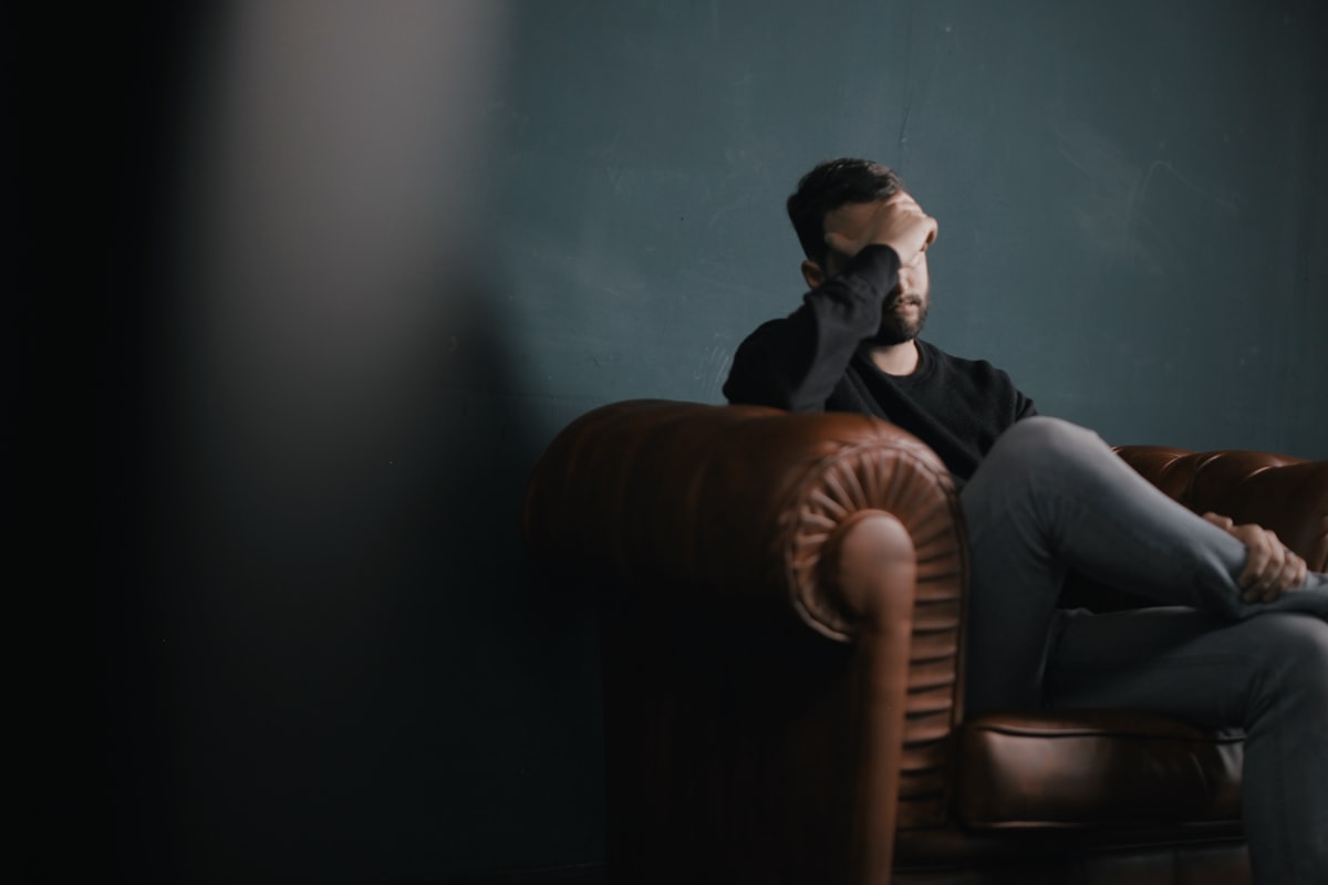 Person sitting alone looking stressed and anxious