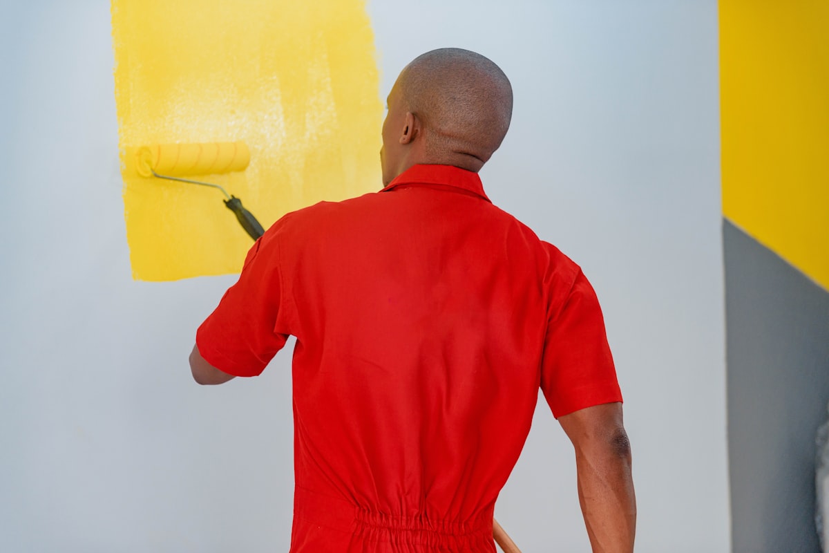 Person painting a wall with a paint roller