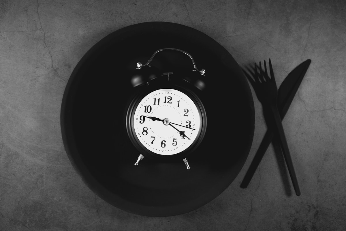 Empty plate with clock representing intermittent fasting