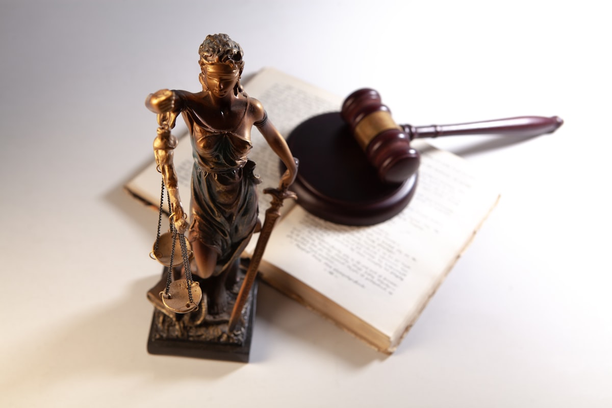 Statue of justice with gavel and open book on a table