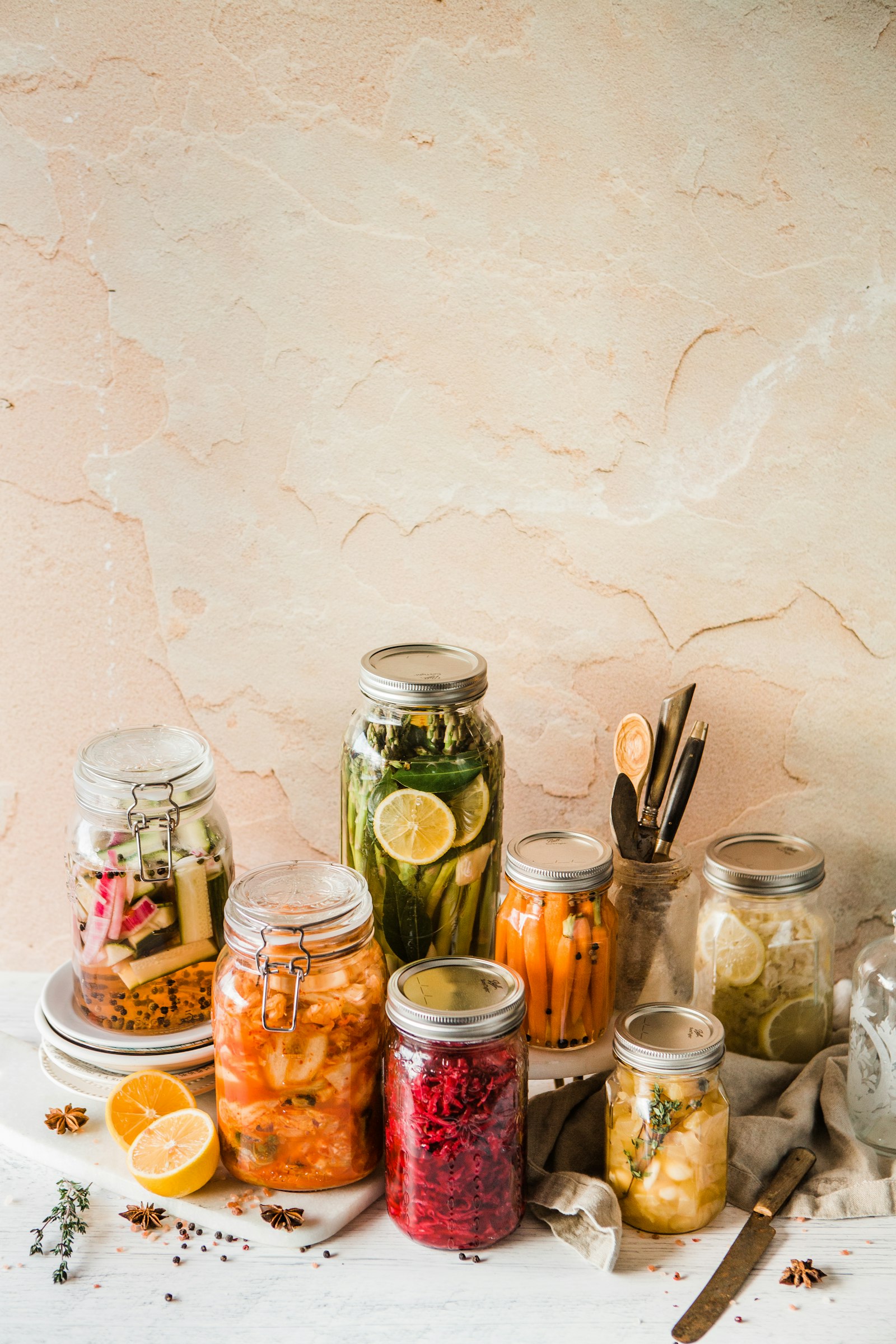 Assorted glass jars of fermented foods including sauerkraut and pickled vegetables