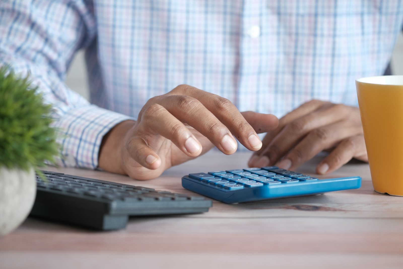 Person using a calculator and salary data to decide how much to ask for in a salary negotiation
